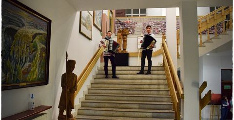 Koncert dwóch akordeonistów na schodach w budynku Muzeum