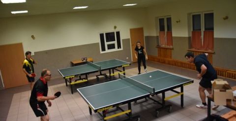 uczestnicy podczas rozgrywek - dwie pary grają przy stołach do ping-ponga